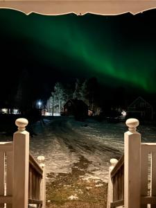 Blick auf die Aurora Borealis über einen Hof in der Unterkunft Sixty Six Degrees North - Lapland Home & Forest in Överkalix
