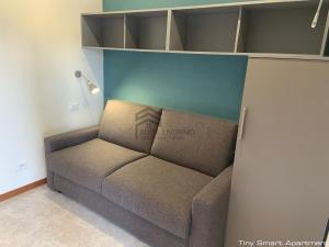 a couch sitting in a room with a wall at Suites Marilia Apartments - Suite Livorno Holiday Home Group in Livorno
