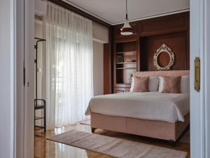 1 dormitorio con 1 cama grande y espejo en Stunning-Classical Penthouse en Atenas