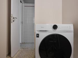 y baño con lavadora y secadora blancas. en Stunning-Classical Penthouse en Atenas