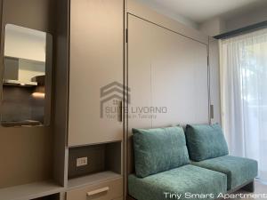a living room with a couch and a mirror at Suites Marilia Apartments - Suite Livorno Holiday Home Group in Livorno