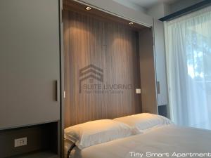 a bedroom with a bed with a wooden wall at Suites Marilia Apartments - Suite Livorno Holiday Home Group in Livorno