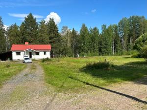 una casa bianca con un tetto rosso in un campo di Sixty Six Degrees North - Lapland Home & Forest a Överkalix