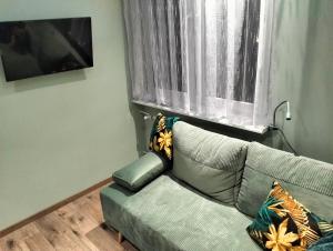 a living room with a couch and a window at Apartament u Bączków in Gdynia +5 photos