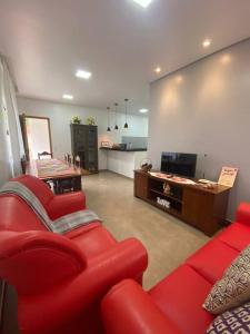 a living room with a red couch and a television at Casa Amoreira in Paraty