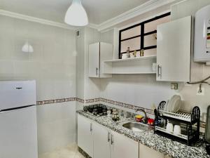 uma cozinha com armários brancos e um lavatório em Tanja tanger moroco em Tânger