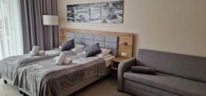 a bedroom with a bed and a couch at Apartament Czarna Góra MOON in Sienna
