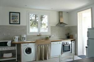 a kitchen with a washing machine and a washer at Maison Vent du Sud in Saint-Trojan-les-Bains +2 photos