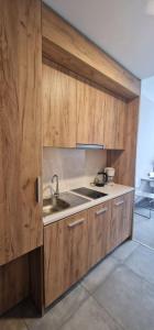 a kitchen with wooden cabinets and a sink at Apartament Czarna Góra MOON in Sienna