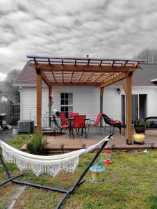 a patio with a wooden pergola and tables and chairs at la casa de Carmen in Charlotte