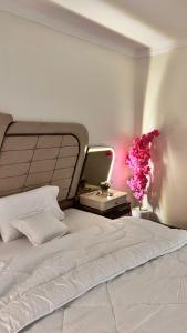a bedroom with a bed with a mirror and flowers at شقة درة الإجابة السياحية in Makkah