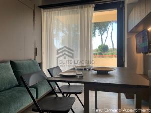 a living room with a table and chairs and a couch at Suites Marilia Apartments - Suite Livorno Holiday Home Group in Livorno
