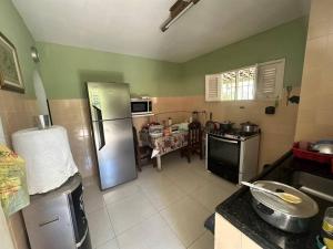 a kitchen with a stainless steel refrigerator and a table at Casa Grande com Piscina no Pilar in Itamaracá