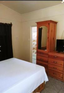 um quarto com uma cama e uma cómoda com um espelho em Andre's Guest House em Negril
