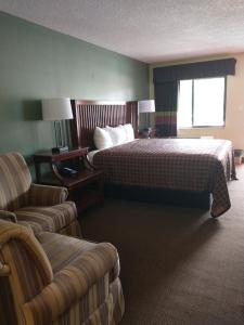 Habitación de hotel con cama y sofá en Apalachicola Bay Inn, en Apalachicola
