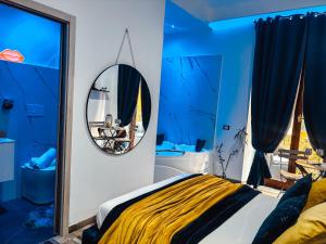una camera blu con letto e specchio di Matriosca Suites a Roma