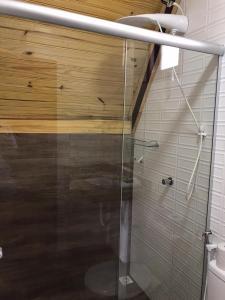W łazience znajduje się prysznic ze szklanymi drzwiami. w obiekcie Chalés Flor do Caparaó em Patrimonio da Penha w mieście PatrimÃ´nio da Penha