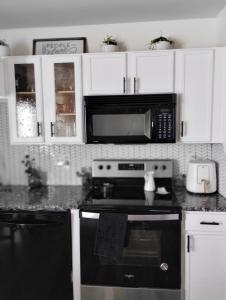 eine Küche mit einem schwarzen Herd und einer Mikrowelle in der Unterkunft la casa de Carmen in Charlotte