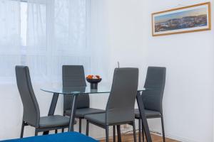 a dining room with a glass table and chairs at Spacious 3BR, 5min Penge St, Crystal Palace Park in Sydenham