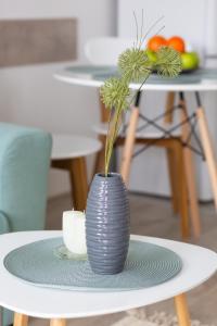 a grey vase sitting on a table with a plate at Apartment KALINA with free private parking in Plovdiv