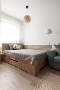 a bedroom with a large bed and a blue couch at Apartment KALINA with free private parking in Plovdiv