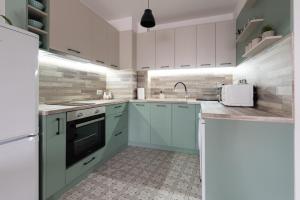 a kitchen with white cabinets and a sink at Apartment KALINA with free private parking in Plovdiv