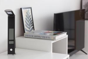 a book sitting on top of a white table next to a tv at Apartment KALINA with free private parking in Plovdiv