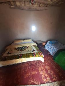 een slaapkamer met 2 bedden in een kamer bij Camp Iguidi Tours in Mhamid