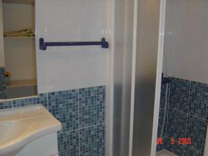 ein Bad mit einer Dusche und einem Waschbecken in der Unterkunft Apartamento Limões in Carvoeiro
