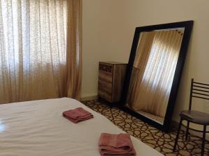 1 dormitorio con cama, espejo y tocador en Sebstian Rooms en Madaba