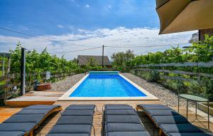 a swimming pool with loungers next to a fence at Greta Rest House in Sopot