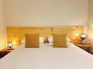 um quarto com uma grande cama branca e 2 almofadas em Oceanus Executive em Ponta Delgada