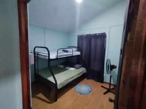 um pequeno quarto com um beliche e um chuveiro em Green Home em Talamanca