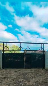 um grande portão preto com um céu azul e nuvens em Green Home em Talamanca