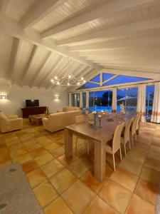 sala de estar amplia con mesa y sillas en Villa Bianca, en Arzachena