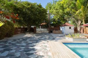 un patio trasero con piscina, árboles y una valla en Villa Gabi - Blue Island, en Punta Rucia