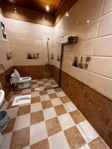 a bathroom with a toilet and a tiled floor at شقق الروشن الجوفي in Al Fayşalīyah