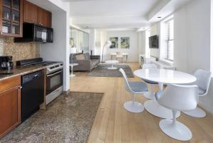 een keuken en een woonkamer met een tafel en stoelen bij PlanURstay - Spacious Midtown West Fully-Serviced - 1BR & 1BTH in New York