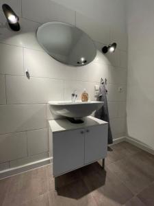 uma casa de banho branca com um lavatório e um espelho em Augusta em Koblenz