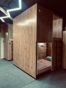 a bed in a room with wooden walls at KOCHEVNIK HOSTEL in Almaty
