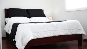 a large bed with a black and white comforter at Casa Roja Residencia 10-51 in Cuenca