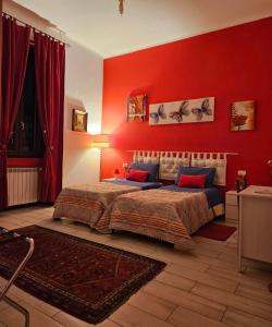 sypialnia z czerwonymi ścianami i łóżkiem w pokoju w obiekcie B&B Villa Emilia Milano w Mediolanie