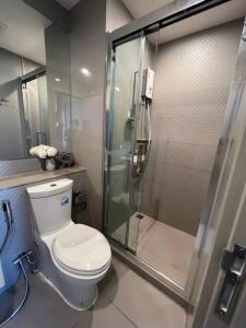 uma casa de banho com um WC e uma cabina de duche em vidro. em The Homey, 3 min walk to Sky train direct to CBD em Bangkok