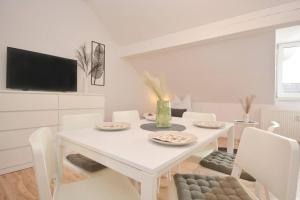 a white dining room with a white table and chairs at RT01-RI Apartment in Roth in Roth