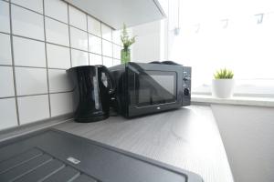 a microwave sitting on a counter next to a laptop at RT01-RI Apartment in Roth in Roth