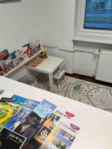 ein Zimmer mit einem Tisch mit Veröffentlichungen darauf in der Unterkunft apartmán Alexandra in Prievidza