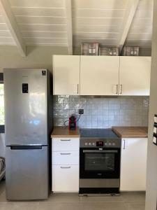 uma cozinha com electrodomésticos de aço inoxidável e armários brancos em Montagna e Mare em Margariti
