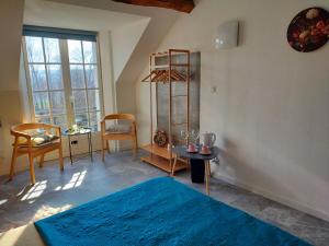 a bedroom with a blue bed and a table and chairs at Chambre d'hôtes Se Sentir Libre Châtaigne in Crozant