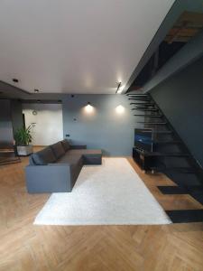 a living room with a couch and a staircase at Luxury_loft in Kamianets-Podilskyi