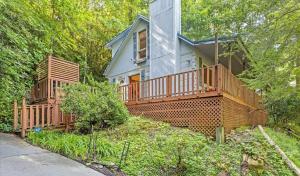 a house with a large deck on the side of it at 2br Rustic Cabin With Hottub And Foosball Table in Gatlinburg